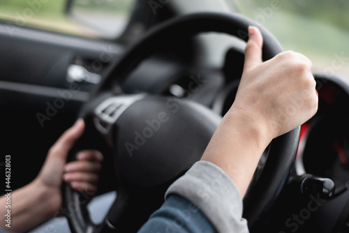 Female hands on the car steering wheel close up. Woman is driving a car. © Natali