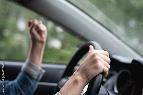 Angry driver shakes her fist in the traffic jam.