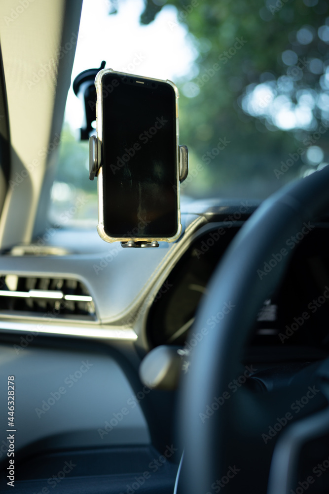 Phone mounted to a windshield of a car in drivers field of view Phone mounted to a windshield of a car in drivers field of view
