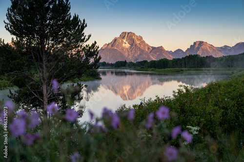 Alpenglow on the peaks of the Grand Tetons mountains during sunrise at Oxbow Bend