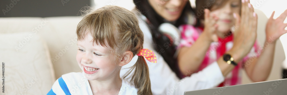 Naklejka premium Children play with mom on the couch and laugh