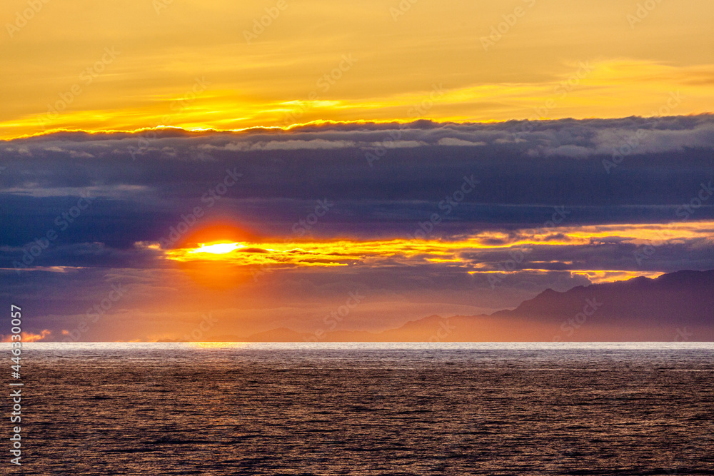 Fototapeta premium A sunset over the NW Pacific coast near Prince of Wales Island, Alaska, USA - Viewed from a cruise ship sailing the Inside Passage