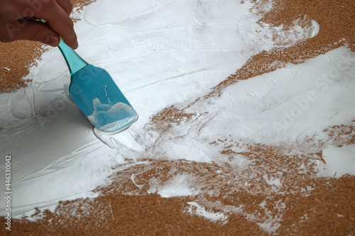 A man applies white plaster with a spatula