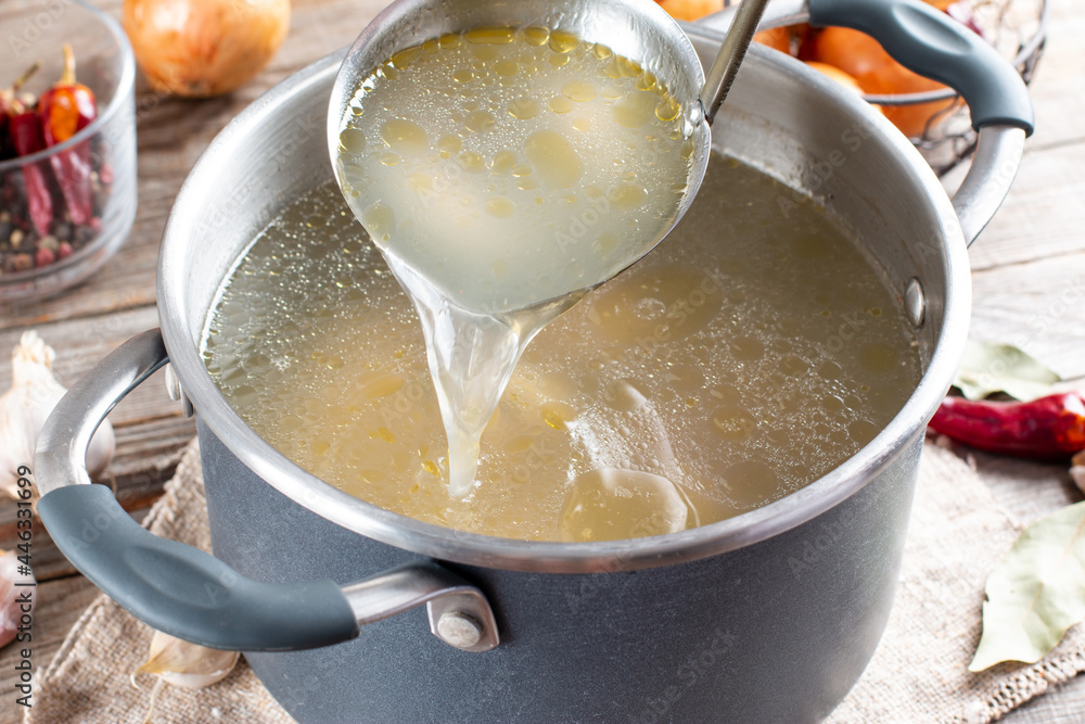 Saucepan with bouillon with a ladle. Bone broth Saucepan with bouillon with a ladle. Bone broth