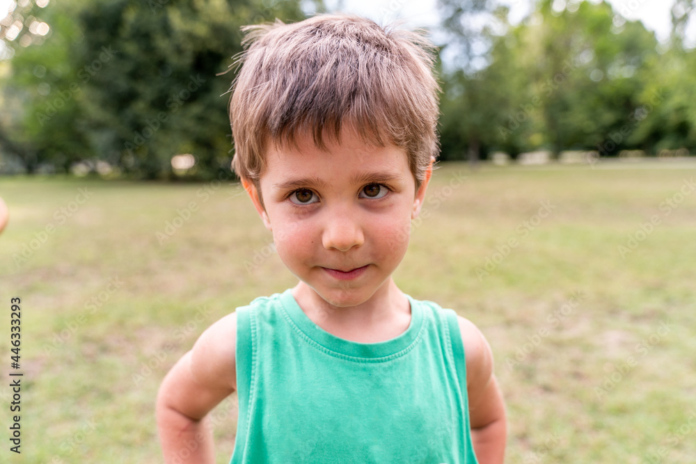 portrait of cute smiling boy in a public park portrait of cute smiling boy in a public park