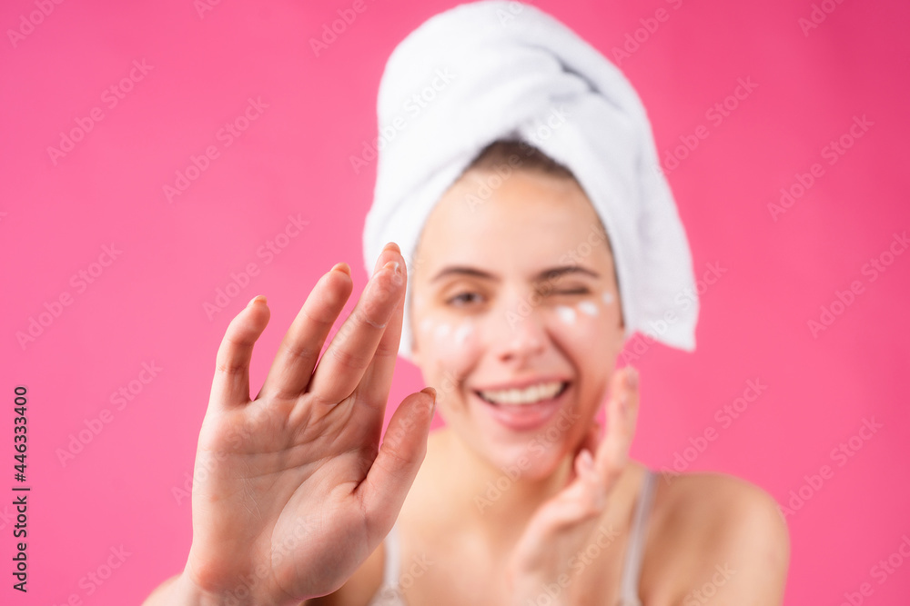 Woman with a facial mask. Charming pretty model after bath wrapped in towel applying using face mask, sensual face. Beautiful woman applying moisturizer on skin using cream touching face. Woman with a facial mask. Charming pretty model after bath wrapped in towel applying using face mask, sensual face. Beautiful woman applying moisturizer on skin using cream touching face.