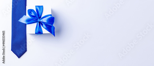 Gift dad. Blue bowtie or tie, white box with bow ribbon on light background. Happy loving family and Fathers Day concept.