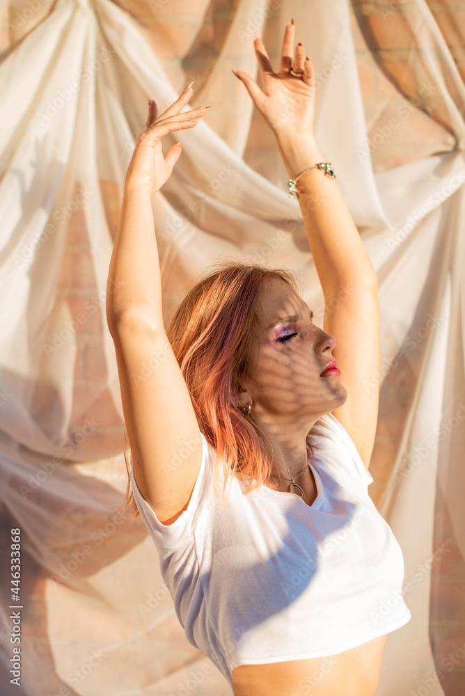 Naklejka premium portrait of a beautiful young girl with a shadow pattern on the face and body .fashion, beauty, makeup, cosmetics, beauty salon, style, personal care, posture. Pink hair. Trend