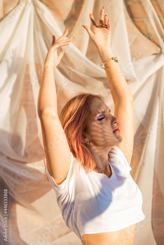 portrait of a beautiful young girl with a shadow pattern on the face and body .fashion, beauty, makeup, cosmetics, beauty salon, style, personal care, posture. Pink hair. Trend