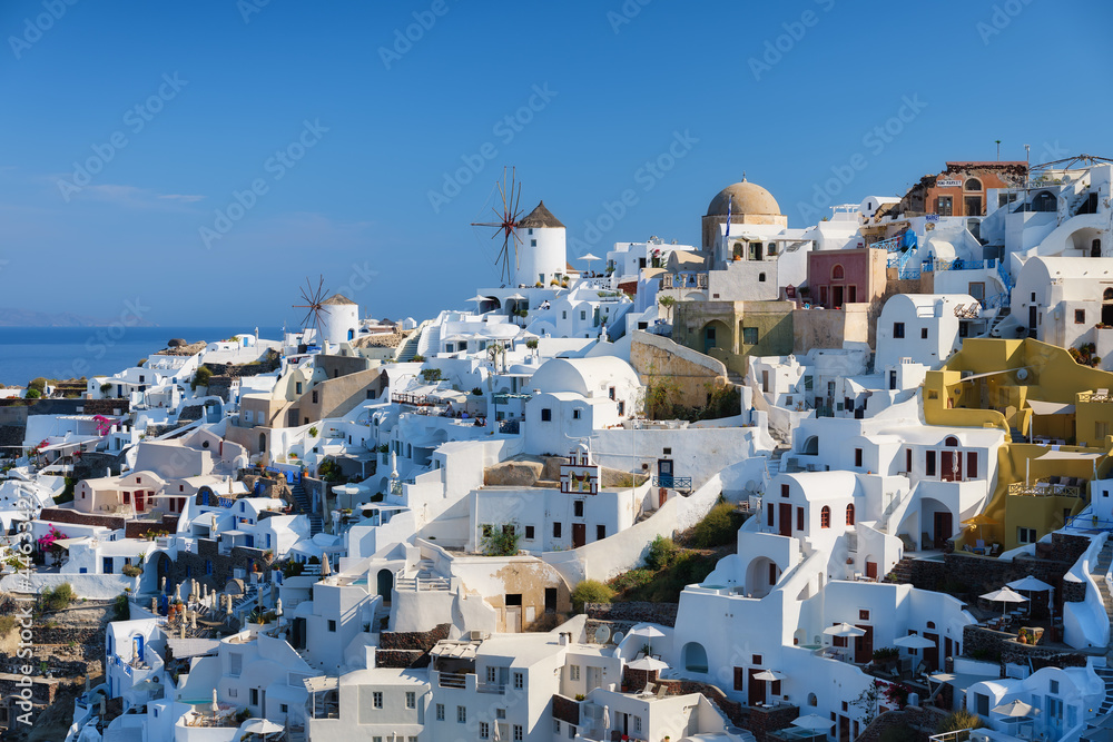 Oia village, Santorini, Greece. View of traditional houses in Santorini. Small narrow streets and rooftops of houses, churches and hotels. Landscape at the day time. Travel and vacation photography.