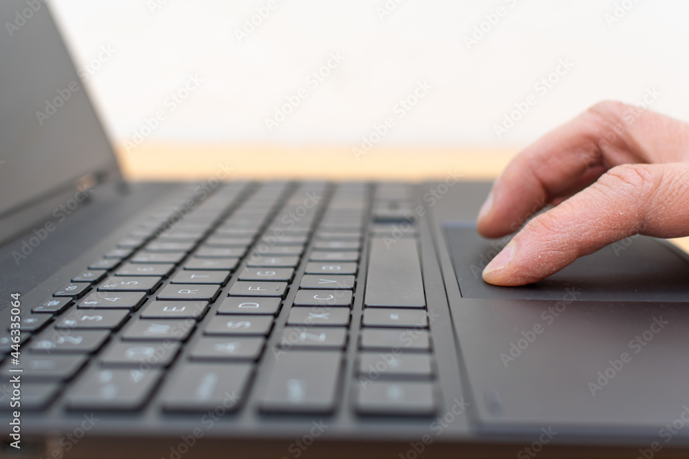 Hand touching the touchpad of the notebook Hand touching the touchpad of the notebook