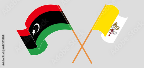 Crossed and waving flags of Libya and Vatican