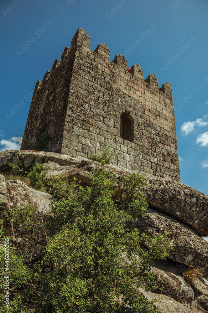 Square tower from keep made of stone over rocky terrain, in a sunny day at the Sortelha Castle. A well preserved medieval village in Portugal.
