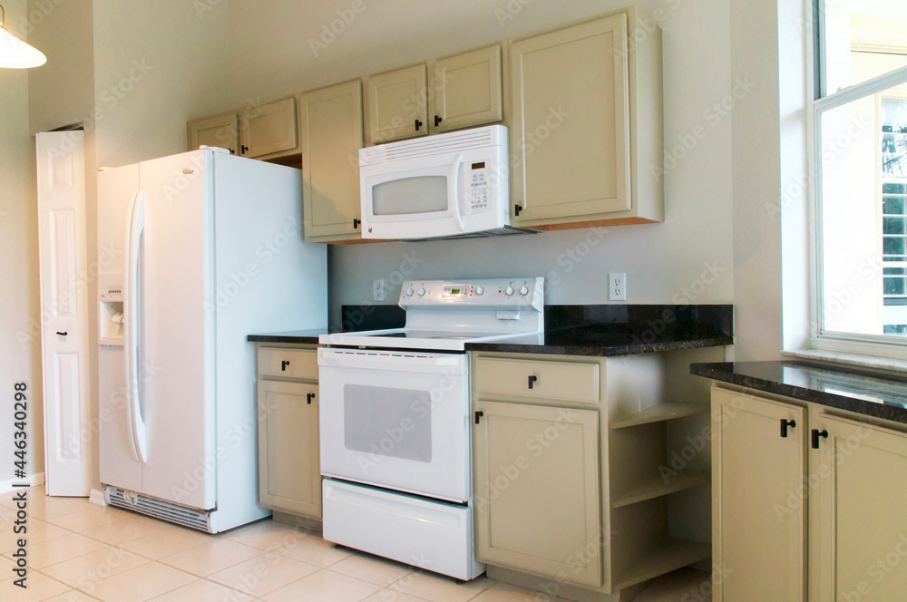 Fototapeta premium empty brightly lit modern kitchen with appliances