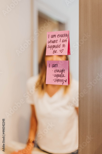 Close up of handwritten affirmations taped to bathroom mirror photo