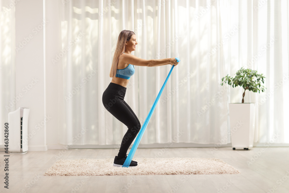 Woman exercising with an elastic rubber band at home Woman exercising with an elastic rubber band at home