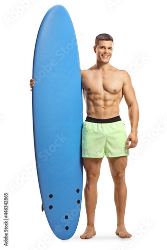 Muscular man with a surfboard standing