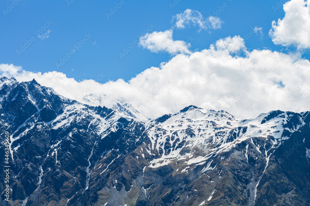 Landscape with majestic rocky peaks of mountains covered with snow on a clear day