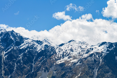 Landscape with majestic rocky peaks of mountains covered with snow on a clear day