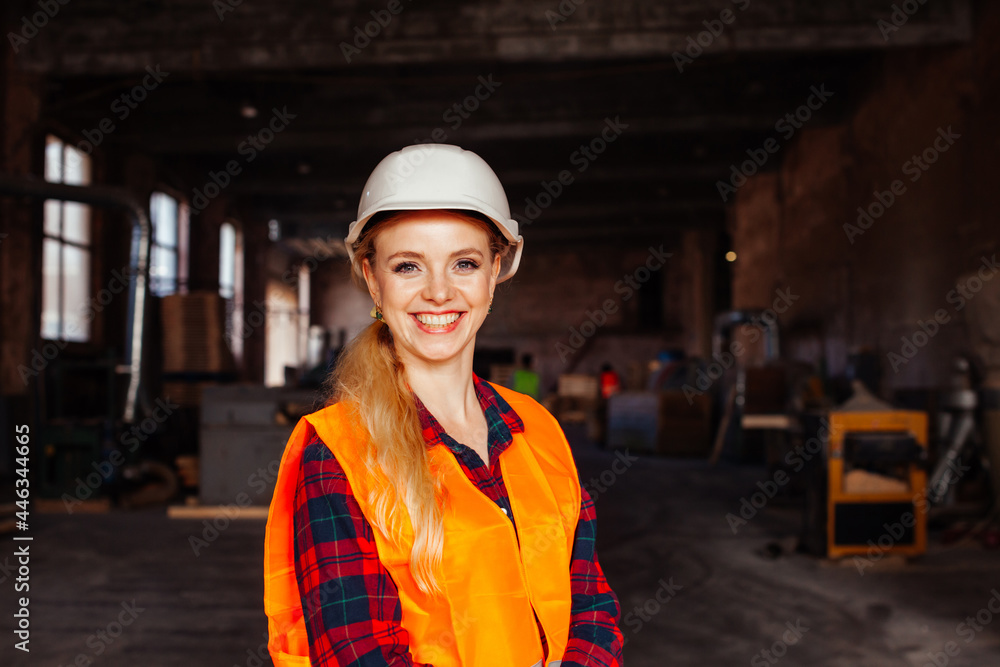 Joyful woman looks at the camera in the factory Joyful woman looks at the camera in the factory