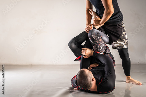 Brazilian jiu jistu bjj no-gi grappling training two male athletes drilling technique from single x guard copy space photo