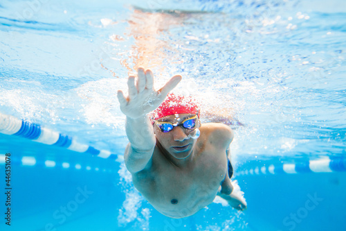 Underwater paralympic disabled Swimmer young latin man Training In Pool, disability concept