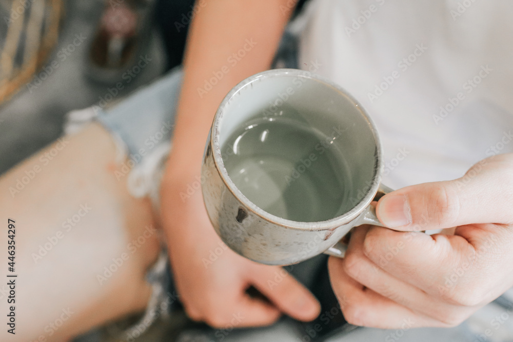 Man holding a ceramic cup of water. Cup of purified water holding in hand. Man drinking healthy beverage. Man holding a ceramic cup of water. Cup of purified water holding in hand. Man drinking healthy beverage.