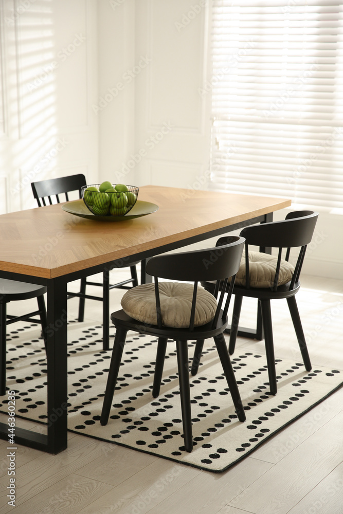 Stylish wooden dining table and chairs in room. Interior design