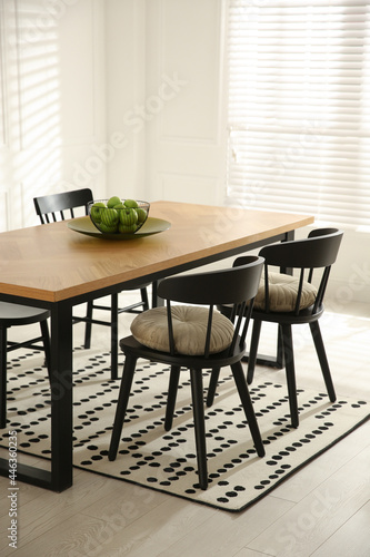 Stylish wooden dining table and chairs in room. Interior design