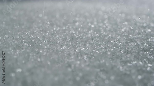 close up selective focus white sugar flowing down on the floor , slow motion shot