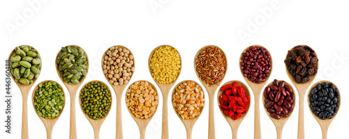 Collection of dry organic green, yellow, brown, red, and dark brown cereal and grain seed in wooden spoon on white background. Concept of healthy food ingredient or agricultural product concept