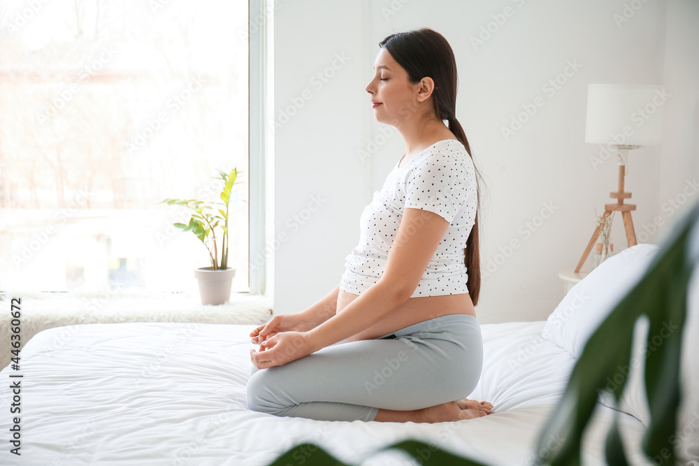 Young pregnant woman practicing yoga in bedroom Young pregnant woman practicing yoga in bedroom