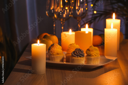 Table with candles and food in dark room