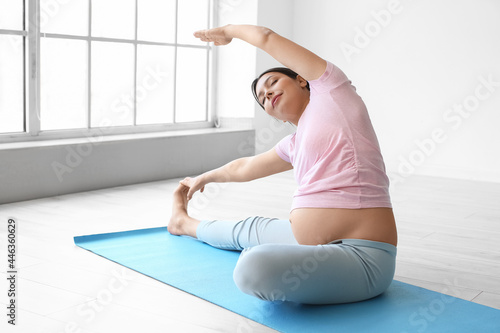 Young pregnant woman practi...