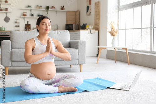 Young pregnant woman practi...