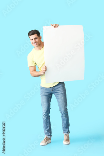 Young man with blank poster...