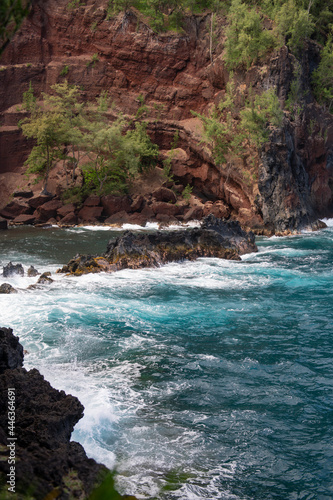 Beautiful ocean beach with large rocks on the shore and in the water. Waves in ocean. Summer holidays, vacation. Red Sand Beach, Maui in in Hawaiian.