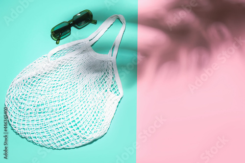 Stylish sunglasses and eco bag on color background