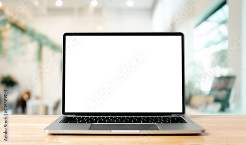 Laptop blank screen on wood table with blurred coffee shop cafe interior background and lighting bokeh, mockup, template for your text, Clipping paths included for background and device screen
