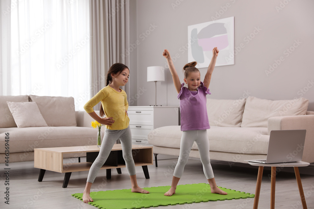 Obraz premium Cute little girls taking online dance class at home