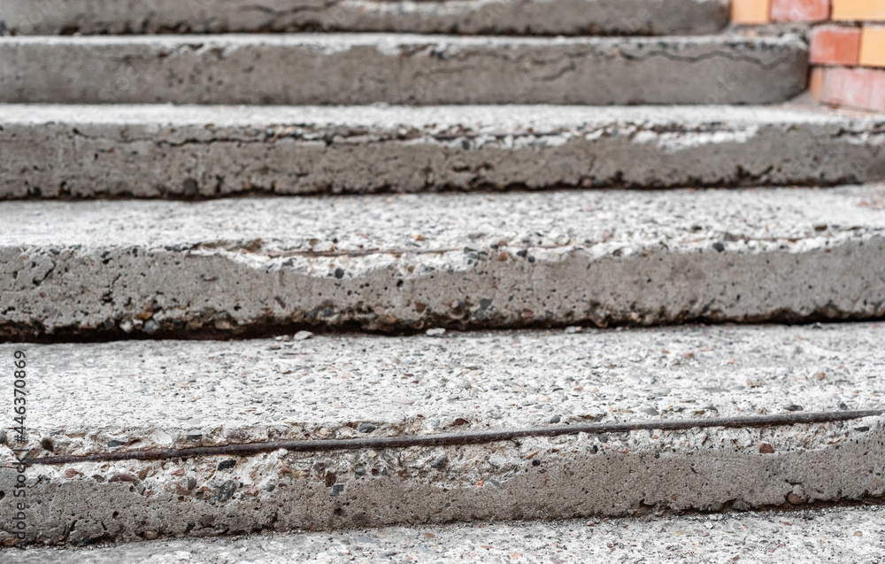 Old broken concrete staircase with protruding iron bars