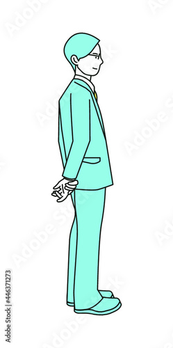 A man in a suit with his hands folded behind his back.