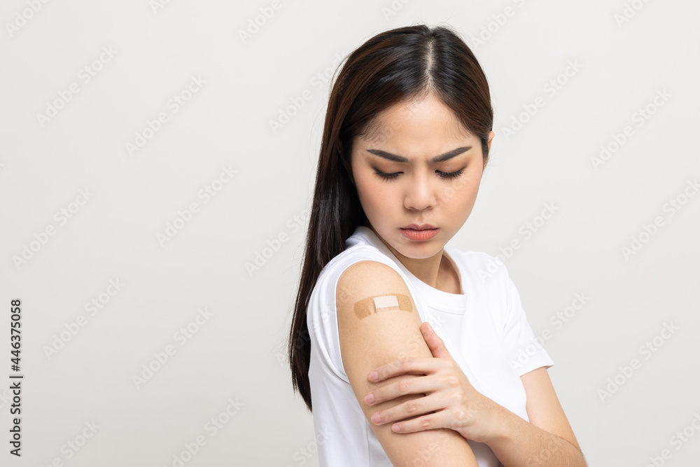 Young beautiful asian woman feel pain in arm after receiving the vaccine. She was worried and stressed that there would be side effects. She tried to massage her aching arm. Young beautiful asian woman feel pain in arm after receiving the vaccine. She was worried and stressed that there would be side effects. She tried to massage her aching arm.