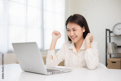 Young beautiful asian business woman finish working and celebrate with two hand stretch in the air. Women finished work and rest She works at home in the living room.