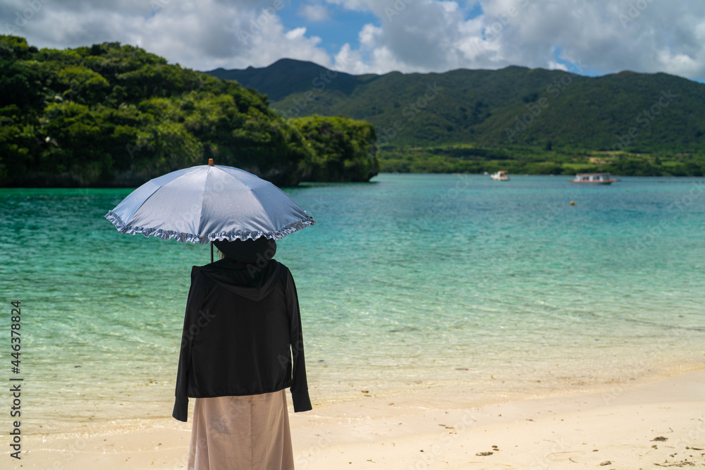 石垣島の川平湾の海に女性が立った風景 沖縄  Landscape of a woman standing in the sea at Kabira Bay, Ishigaki Island, Okinawa. 