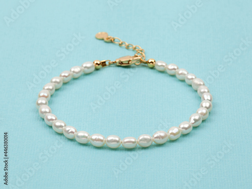 Luxury elegant baroque pearl bracelet on bright turquoise textured background