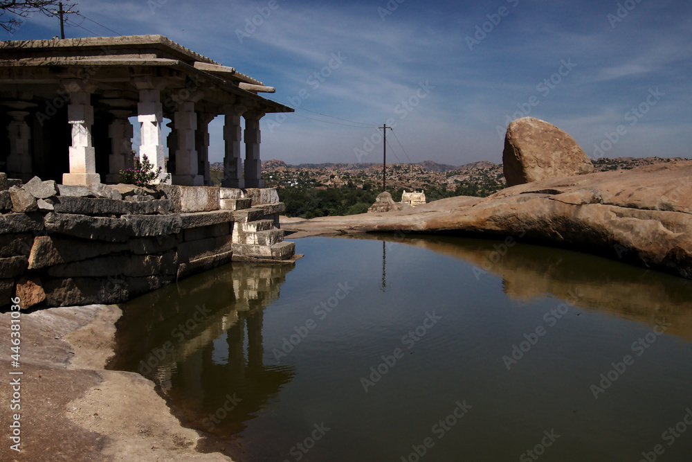 Fototapeta premium Temple on a pond overlooking the valley from Hemakuta Hill in Hampi, India