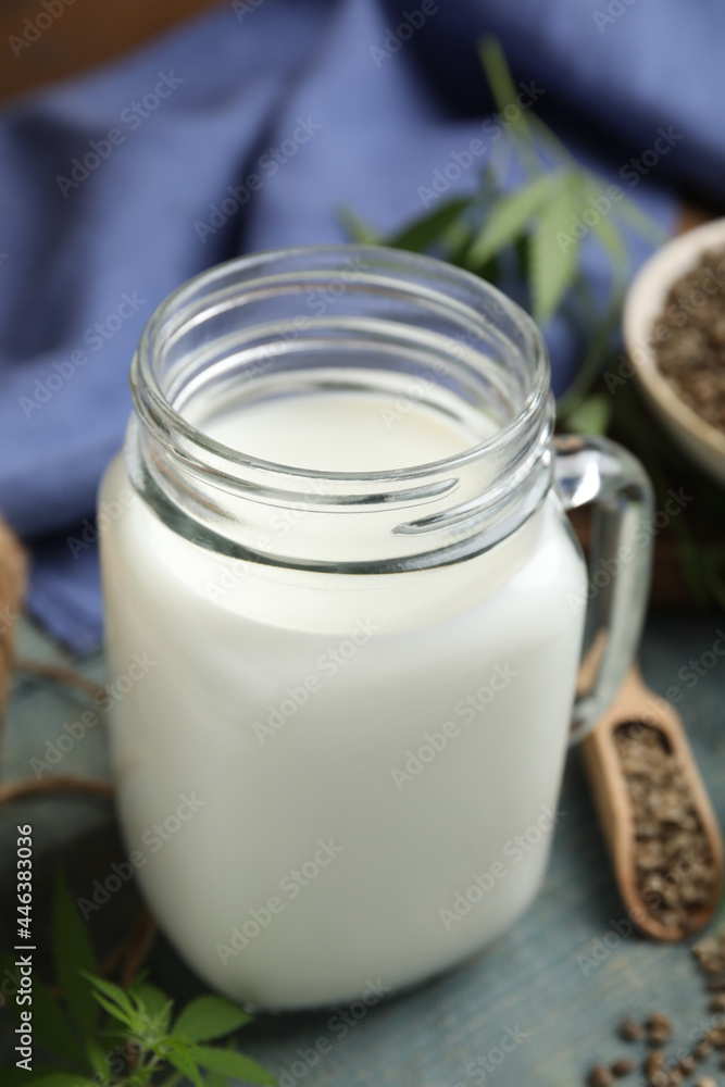 Mason jar of fresh hemp milk on light blue wooden table Mason jar of fresh hemp milk on light blue wooden table