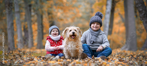Foto lachende Kinder mit Hund im Wald