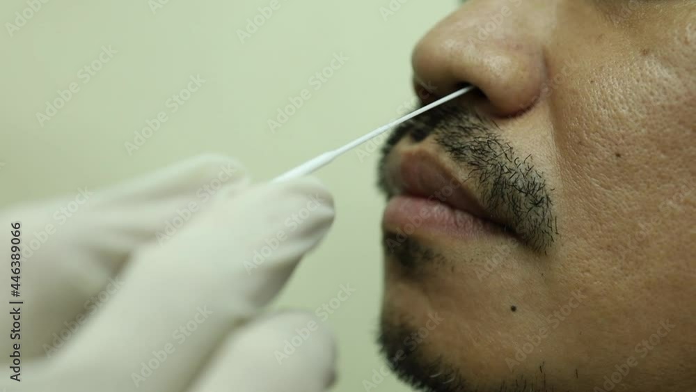 nasopharyngeal swab asian man closeup rapid antigen test active